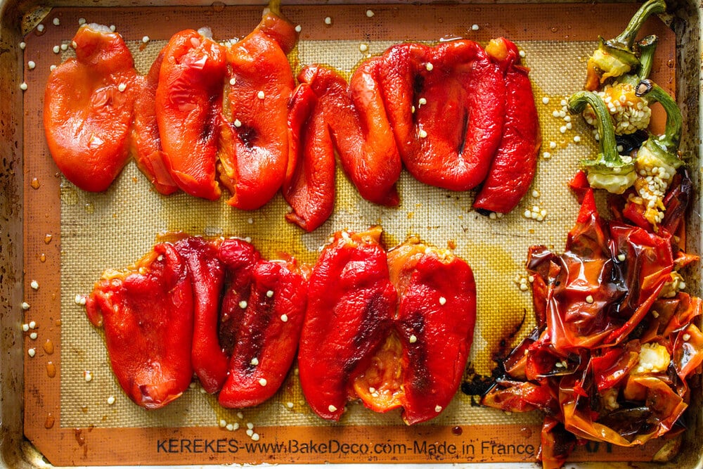 roasted red peppers steamed and peeled on a rimmed baking sheet.