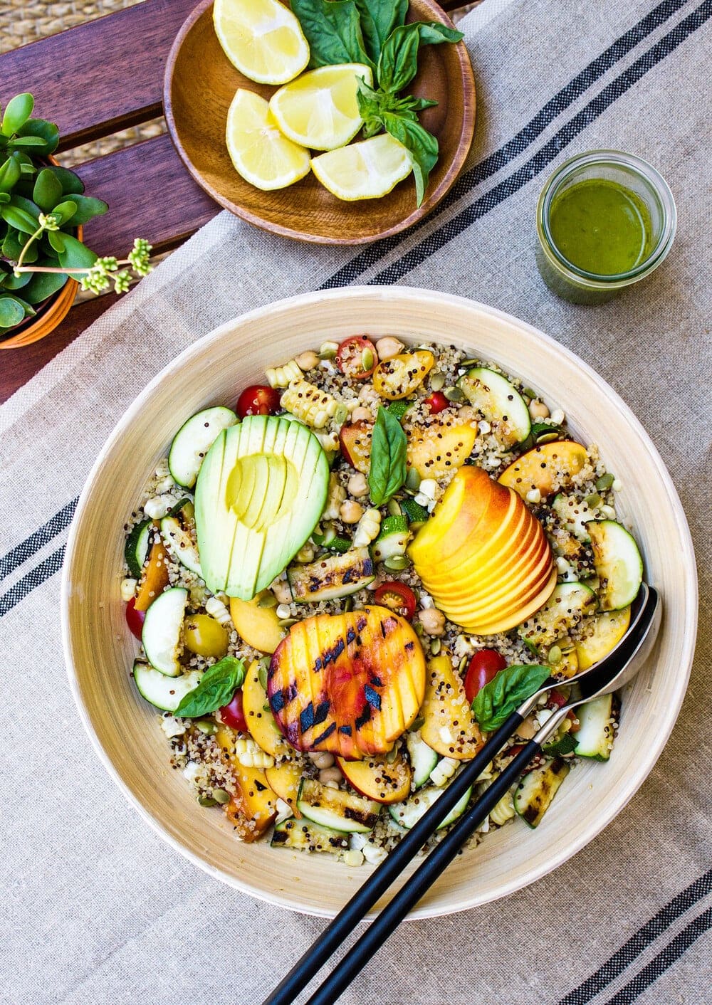 top down view of grilled peach, corn and zucchini quinoa salad in a large mixing bowl before the dressing is added.