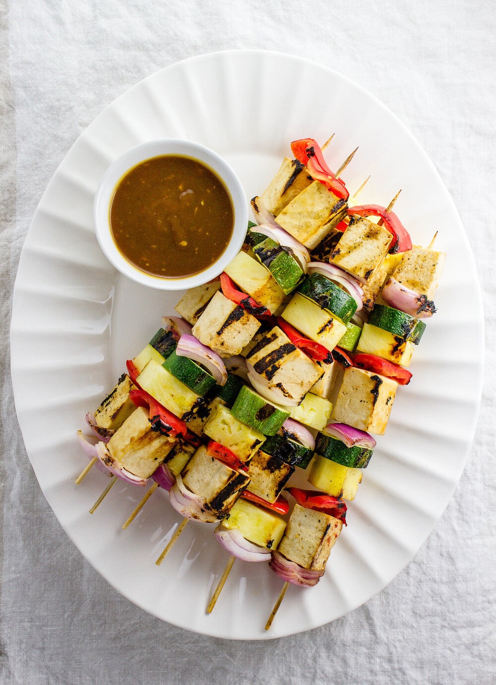 top down view of a serving platter with 6 grilled tofu skewers.