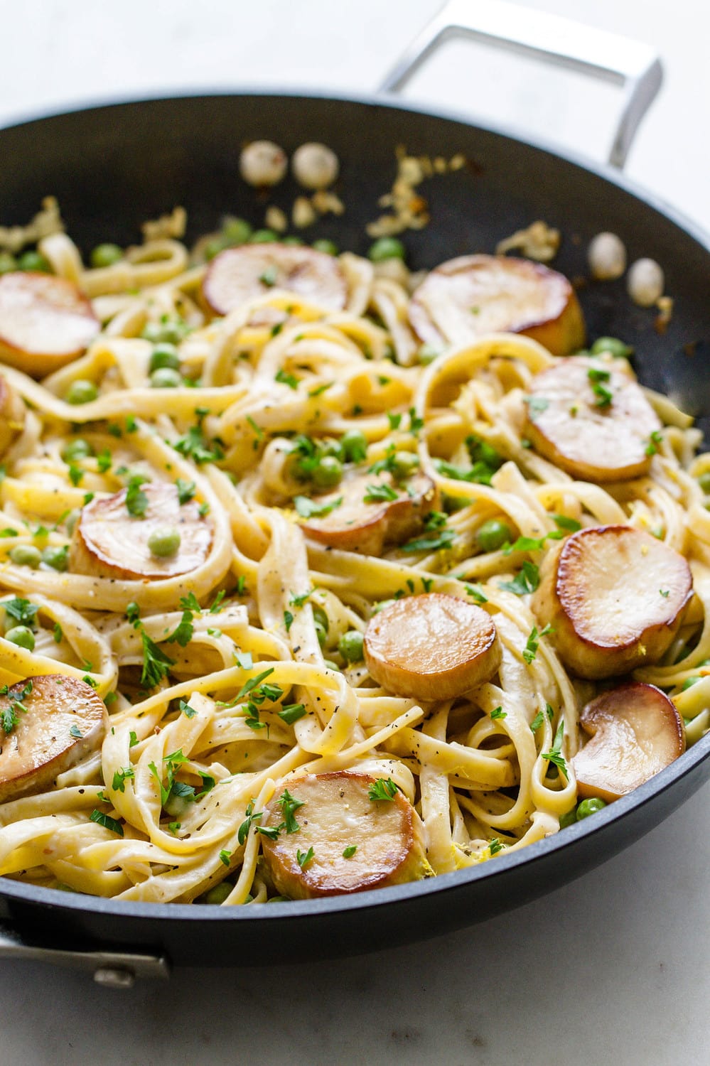 side view of skillet with fettuccine alfredo mixed all together and ready to serve