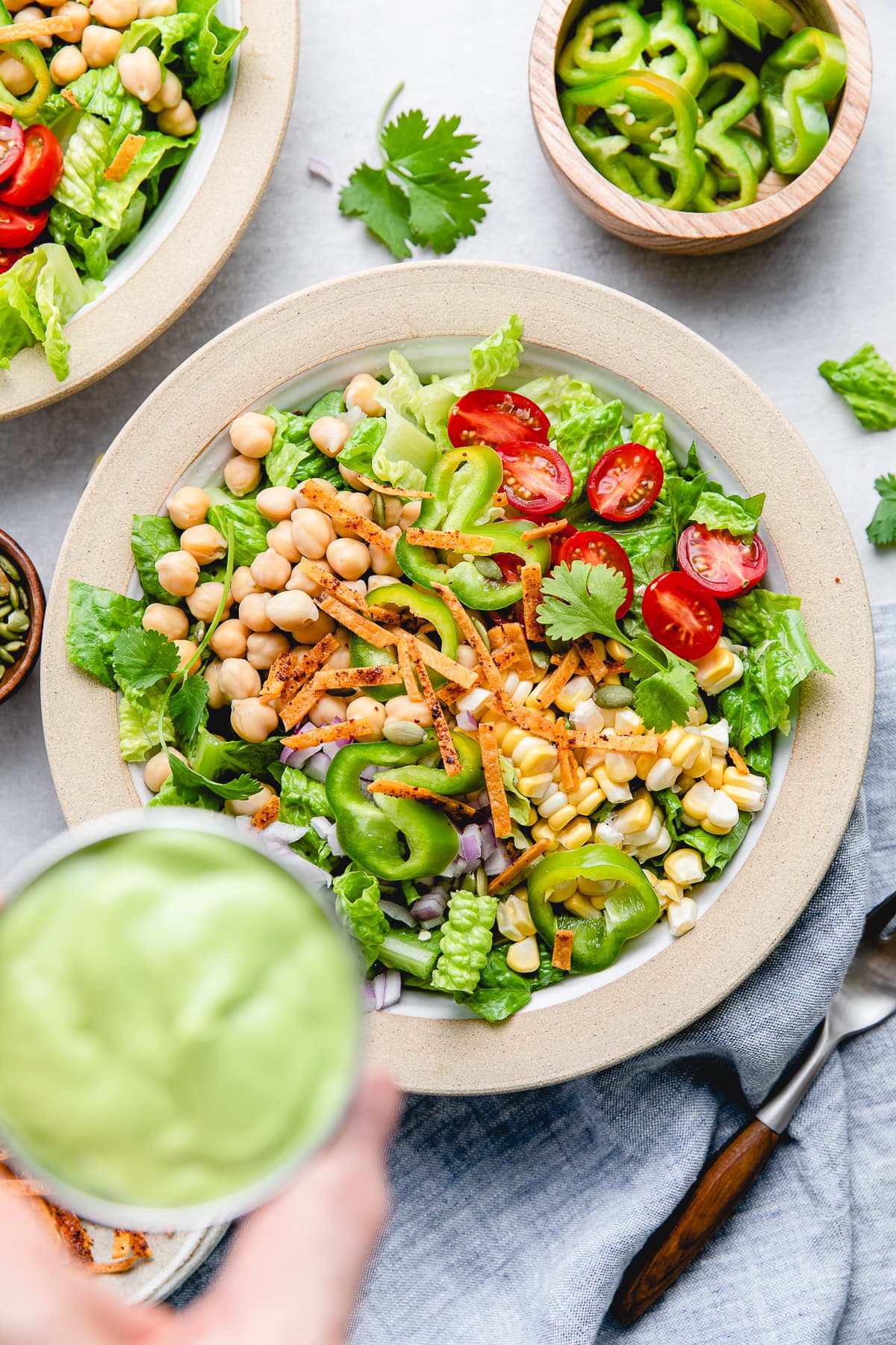 top down view of bowl with southwest chickpea salad and avocado dressing about to be poured over the top.