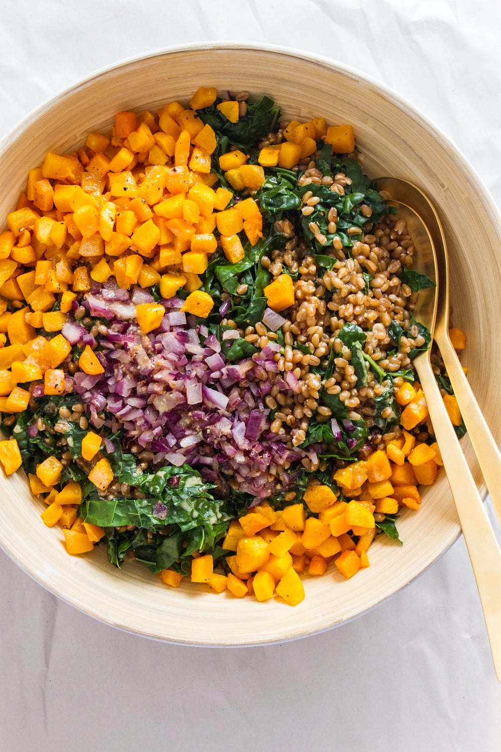 top down view of ingredients for wheat berry and butternut squash add to a mixing bowl, ready to be mixed.