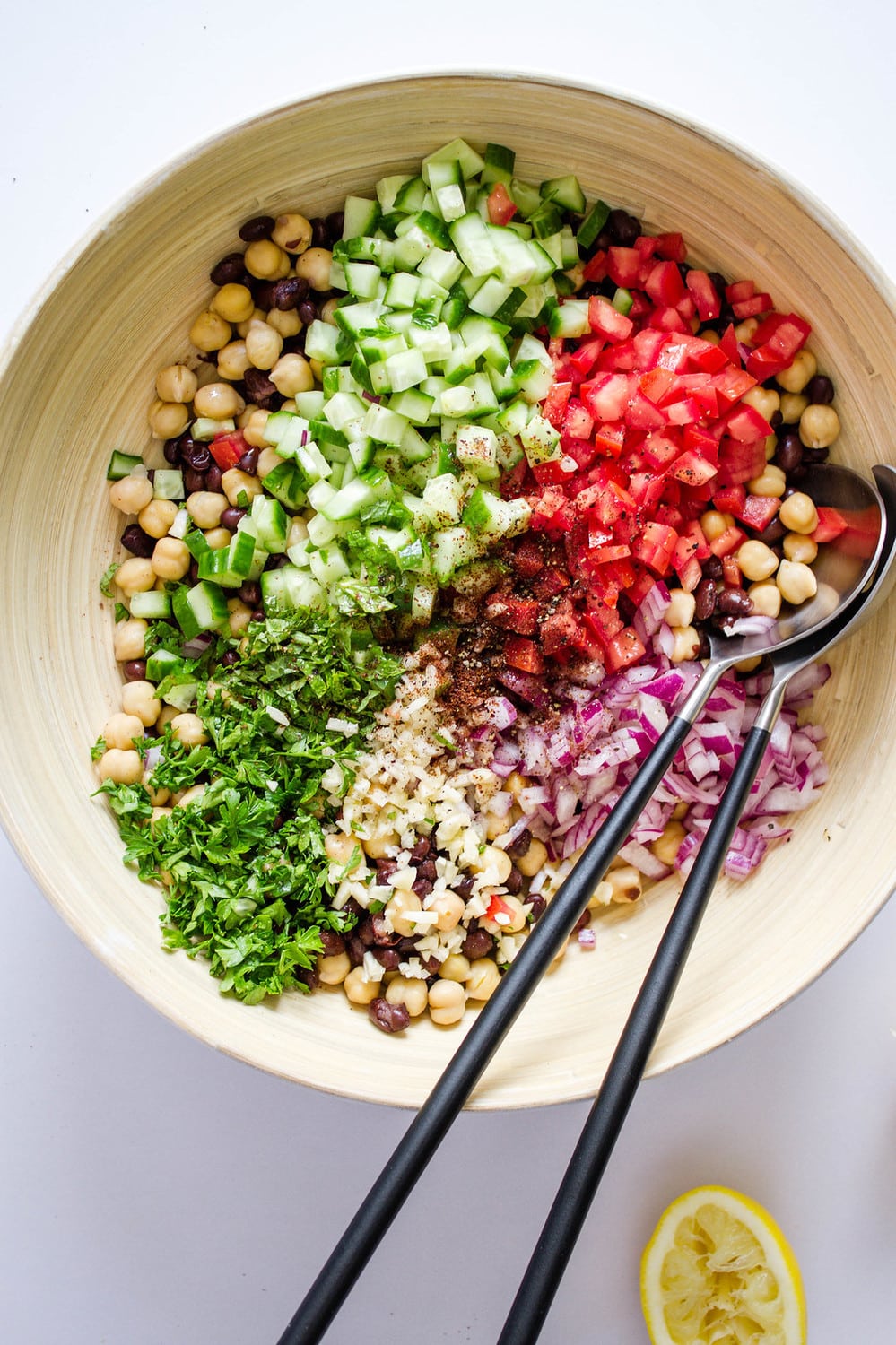 top down view of the ingredients for balela salad added to mixing bowl before mixing