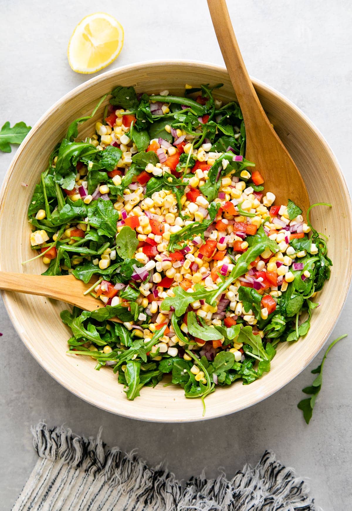 top down view of freshly tossed corn arugula salad.