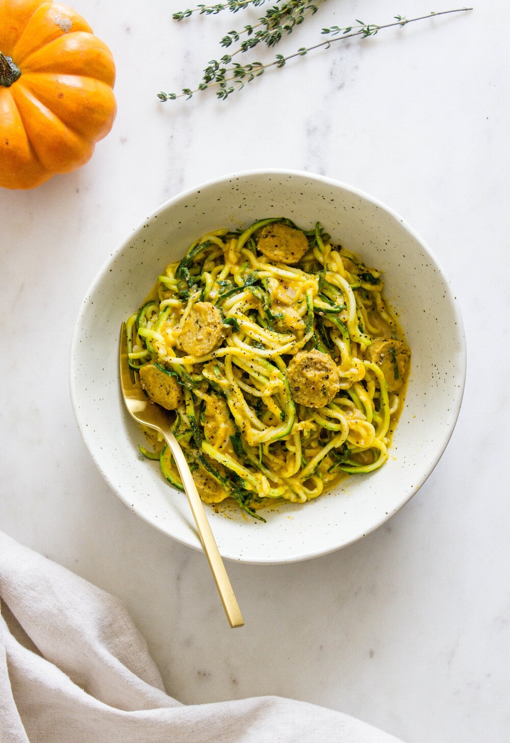 top down view of creamy pumpkin sauce with kale and mushrooms, tossed with zucchini noodles.
