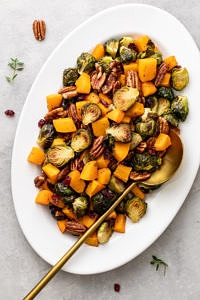 top down view of serving platter with roasted brussels sprouts and butternut squash with cranberries and pecans.
