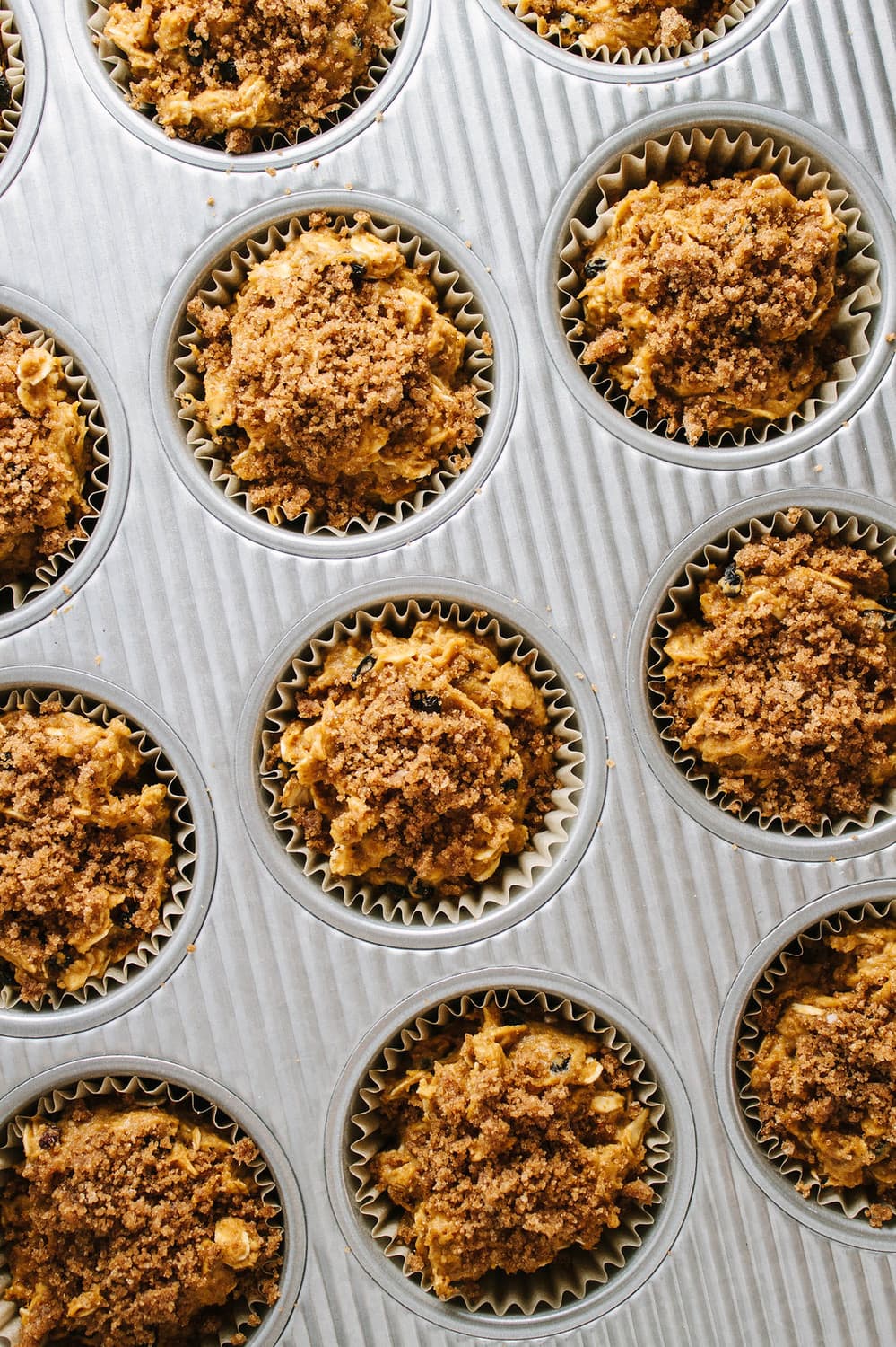 top down view of freshly baked pumpkin oat muffins in a muffin tin just pulled from the oven