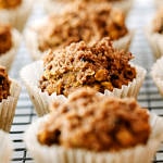 head on view of vegan pumpkin oat muffins cooling on a wire rack.
