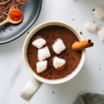 down view of Mexican hot chocolate in a mug with items surrounded.
