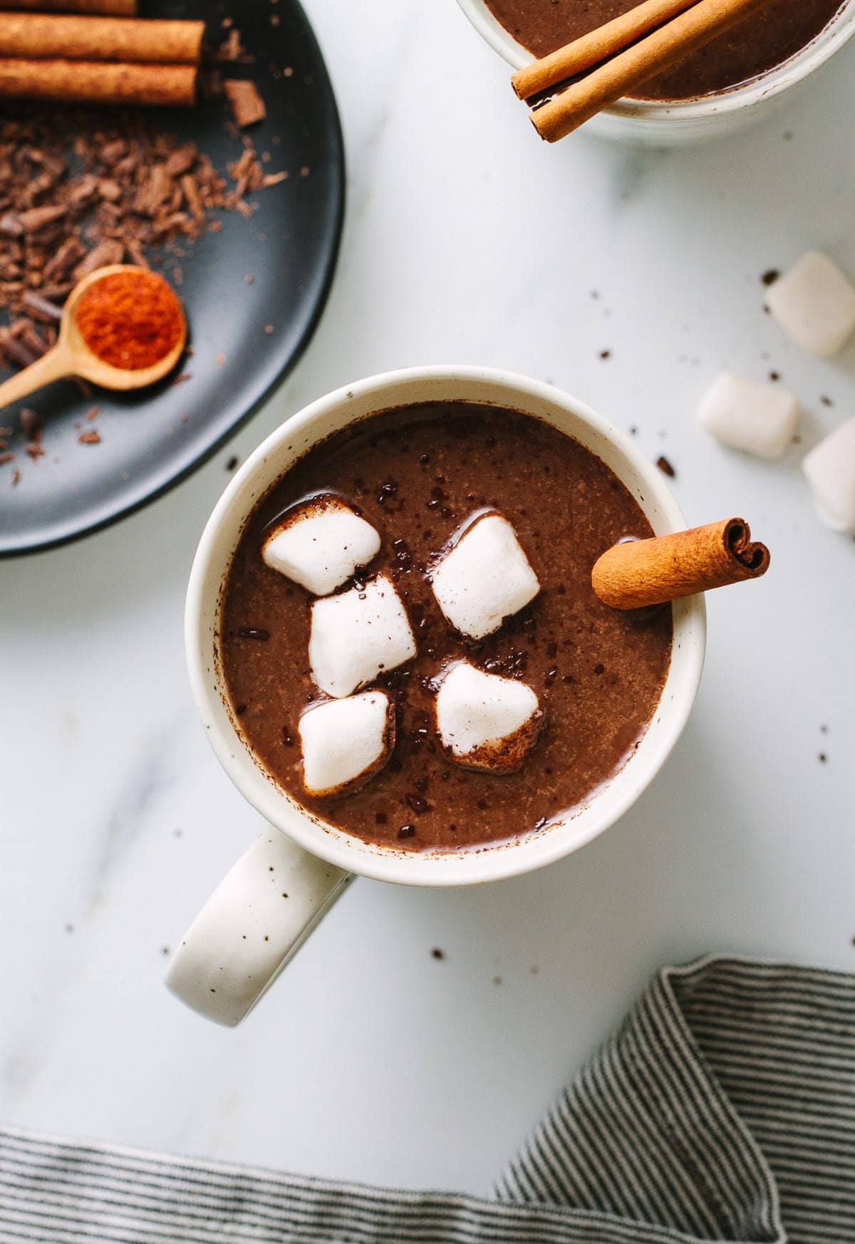 down view of Mexican hot chocolate in a mug with items surrounded.