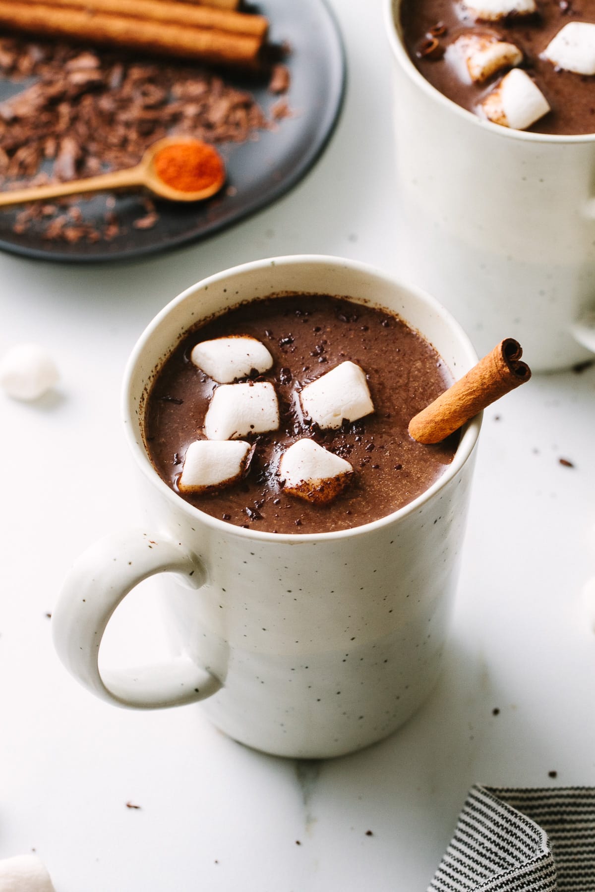 side angle view of Mexican hot chocolate in a mug with items surrounded.