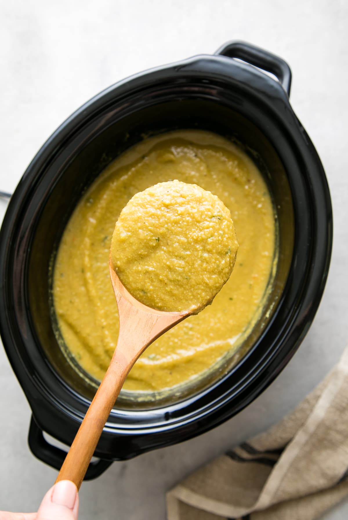 top down of a ladle filled with vegan split pea soup.