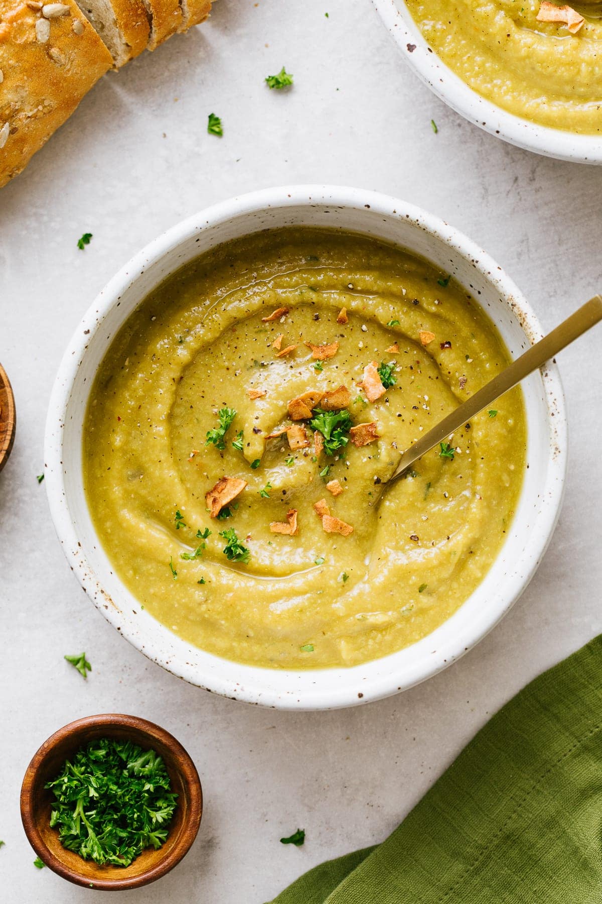 top down view of bowl of healthy vegan split pea soup with items surrounding.