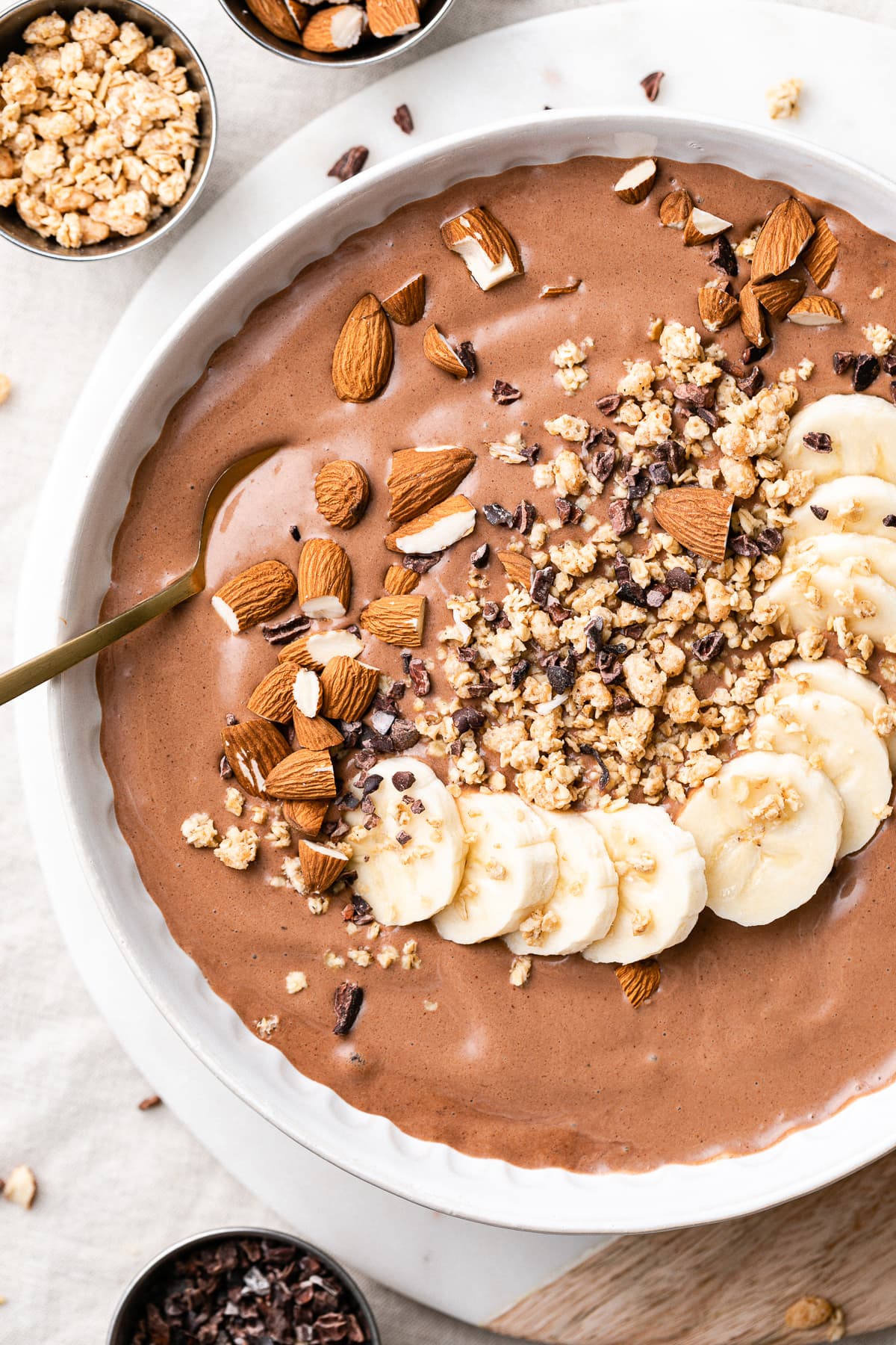 top down view of chocolate almond butter smoothie in a bowl with toppings.