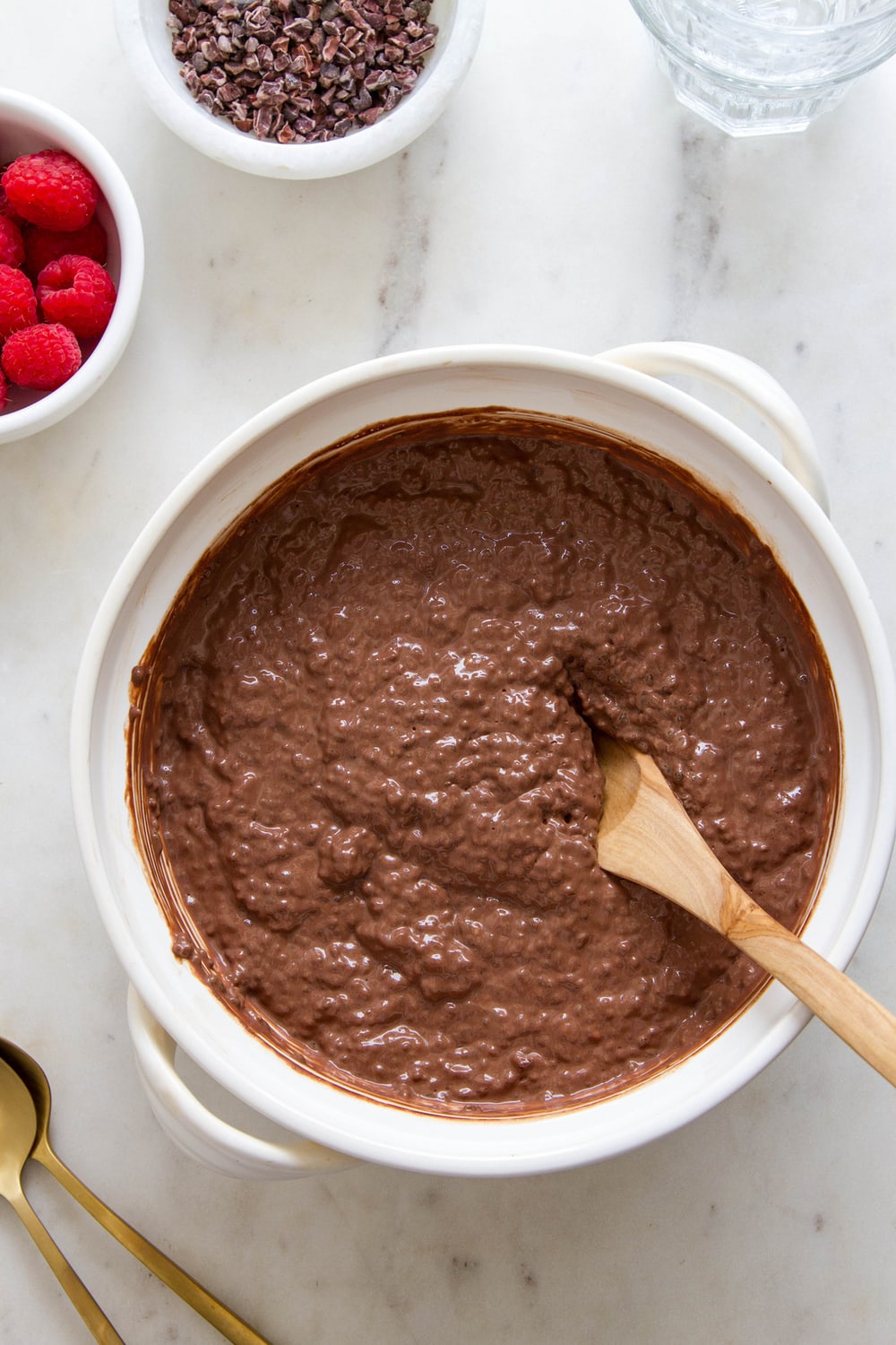 top down view of chocolate chia pudding in a bowl with items surrounding.