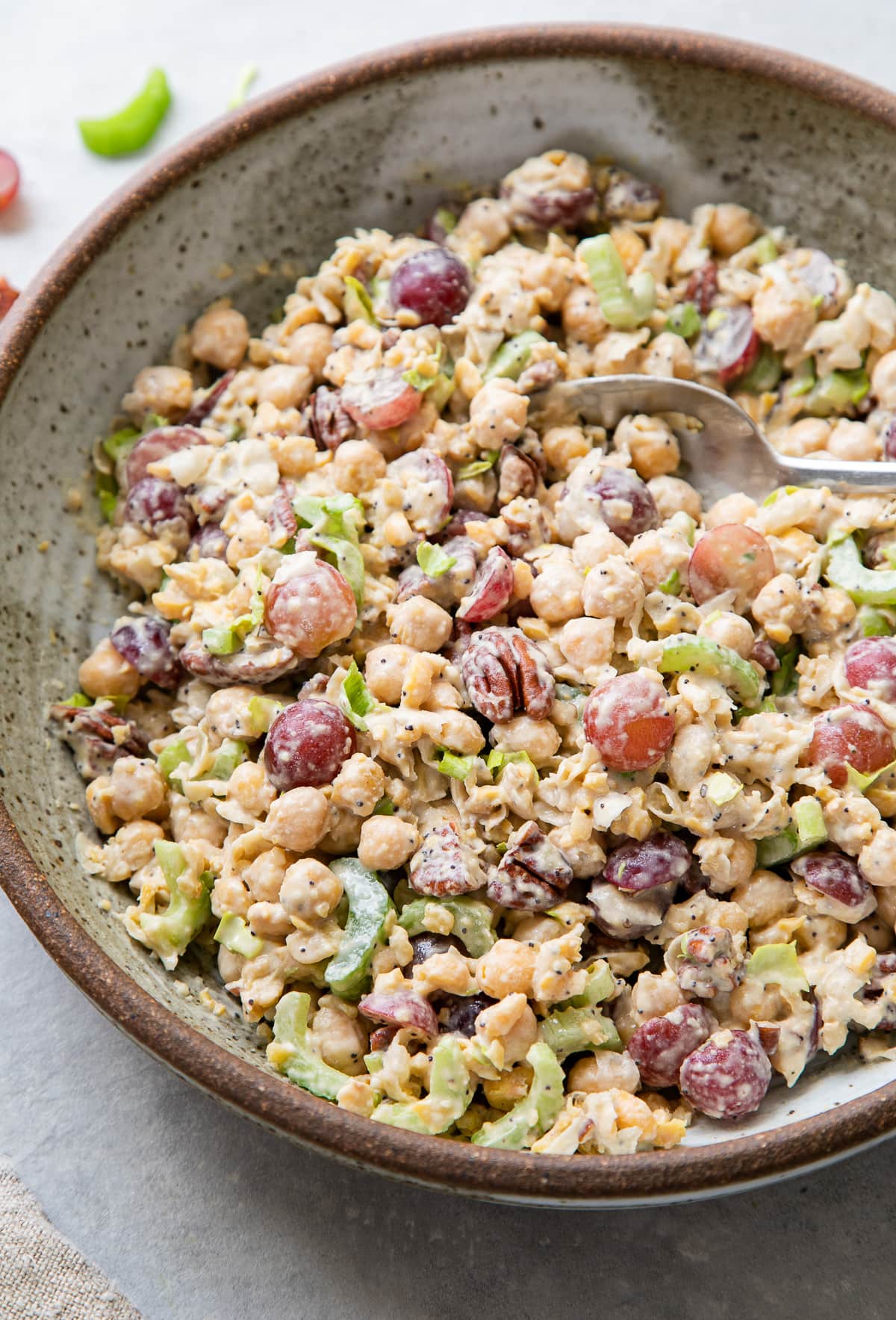 side angle view of freshly made sonoma chickpea chicken salad in a bowl with spoon.