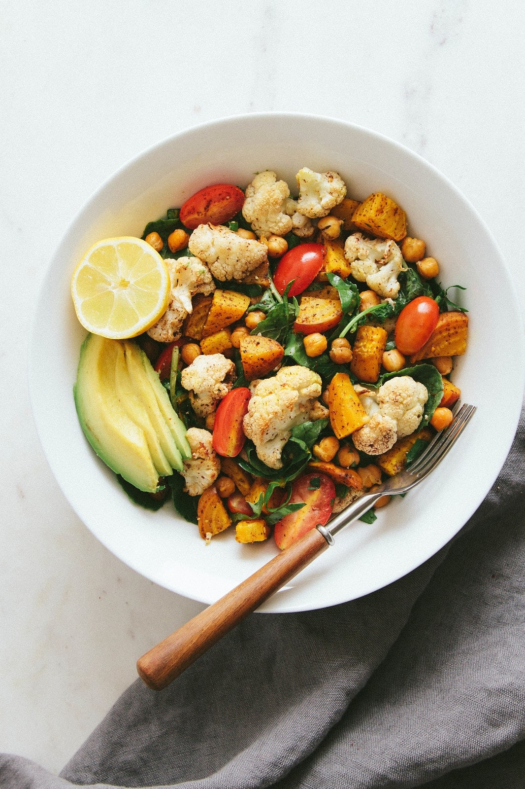 top down view of a bowl filled with a serving of roasted cauliflower, golden beet and chickpea salad.