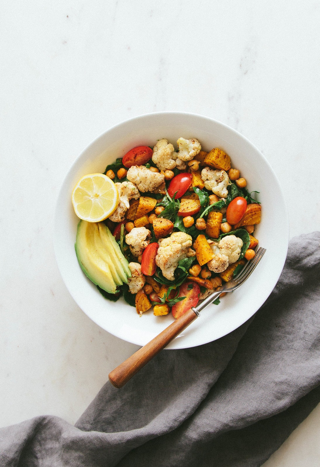 top down view of a bowl filled with a serving of roasted cauliflower, golden beet and chickpea salad.