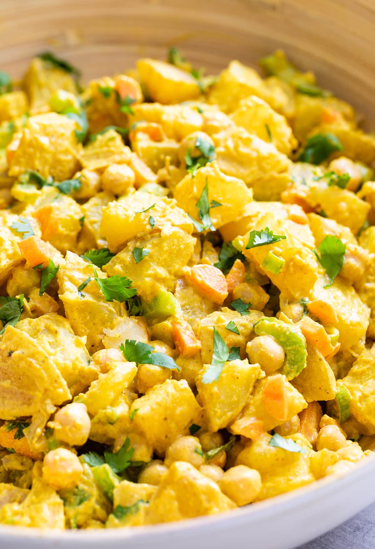 side angle view of vegan curried potato salad in a bowl.