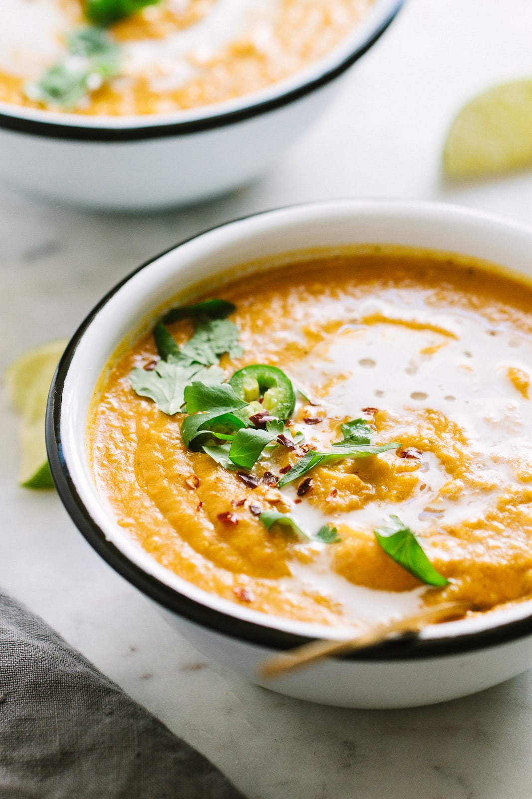 side angle view of bowl of curry sweet potato soup in a bowl with spoon.