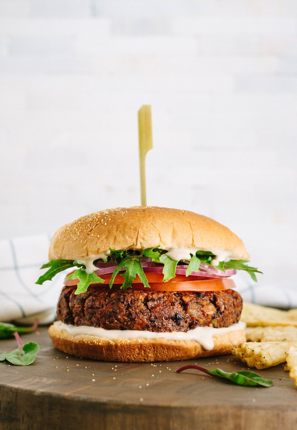 head on view of smoky black bean burger on a wooden cutting board.