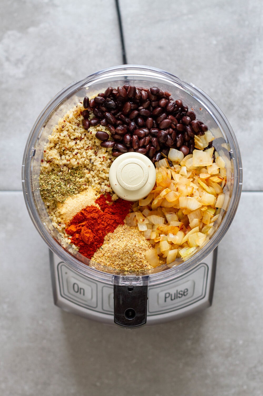 top down view of ingredients for vegan black bean burgers in a food processor. 