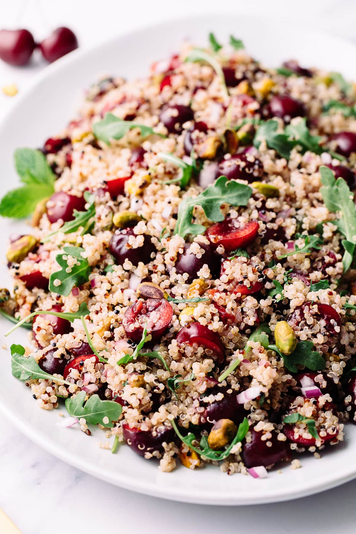 side angle view of serving platter with cherry pistachio quinoa salad.