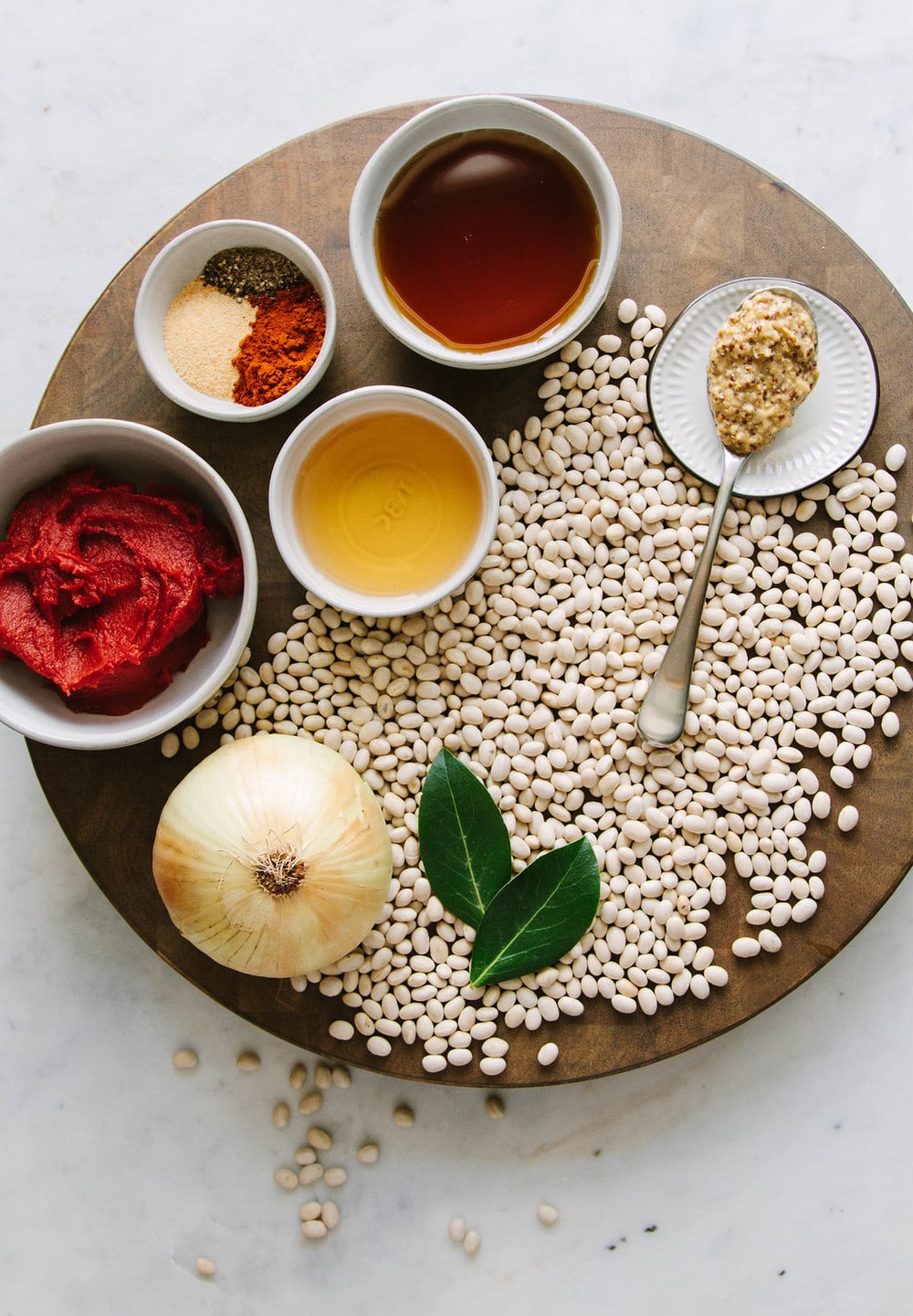 ingredients for baked beans on a circular wooden cutting board