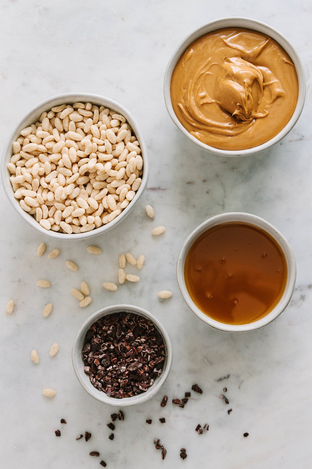 top down view of ingredients for rice krispy treats: peanut butter, brown rice syrup, rice cereal and cacao nibs