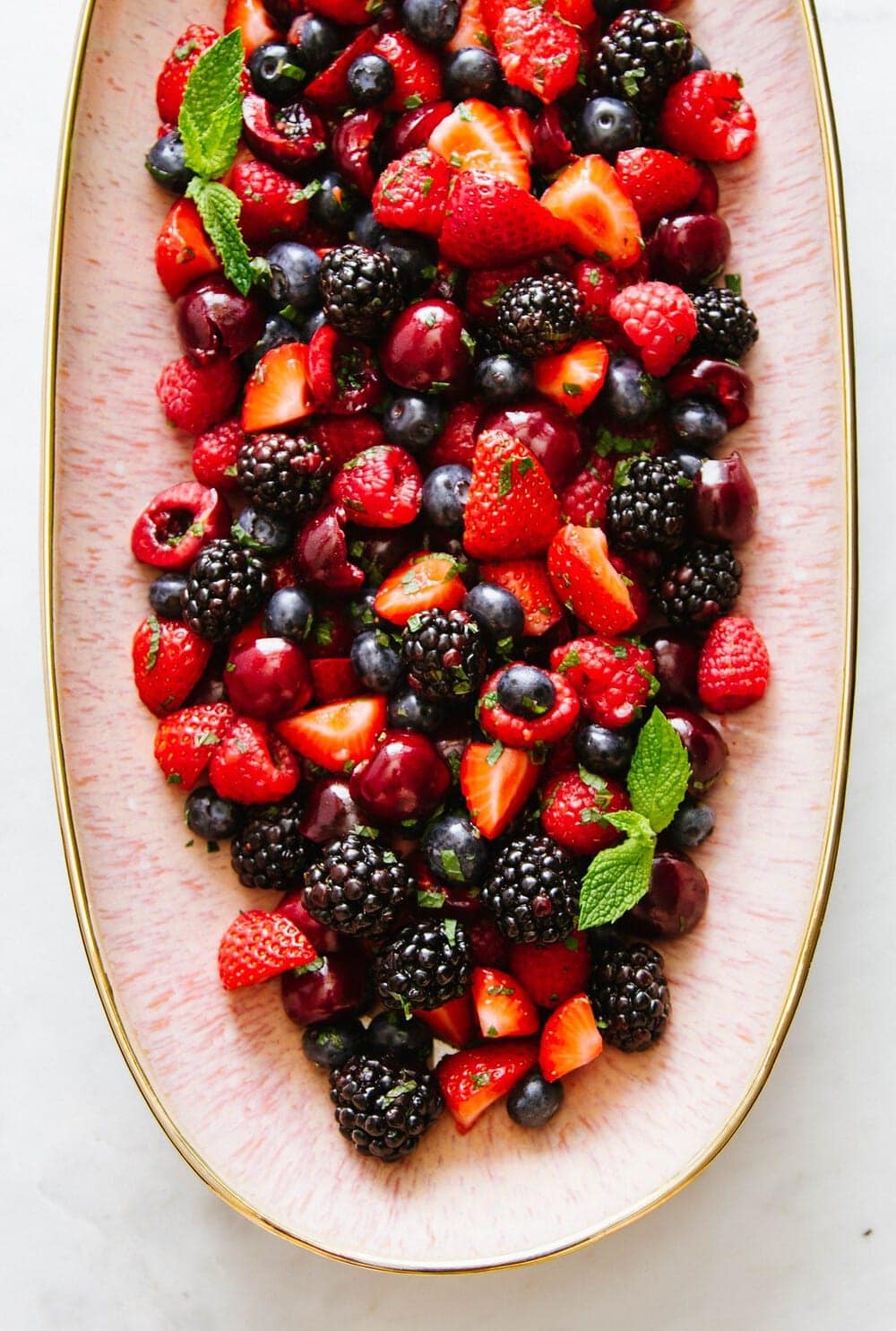 summer cherry berry fruit salad on a pink platter