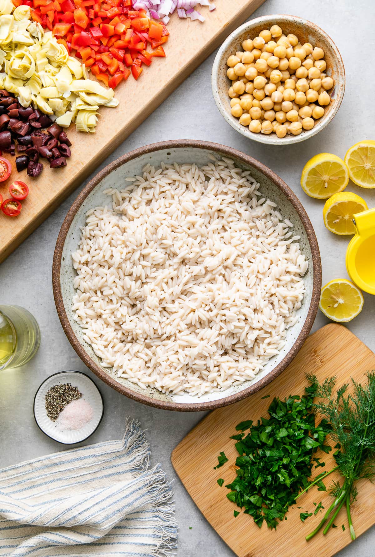 top down view of orzo cooked and ingredients prepped before mixing orzo salad together.