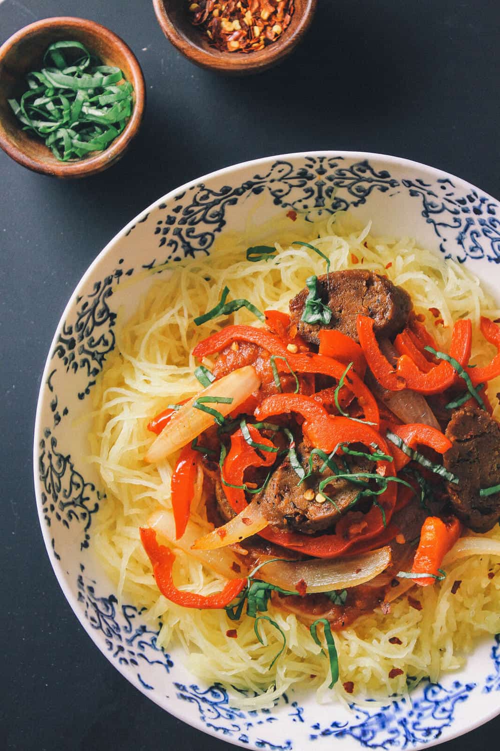 spaghetti squash with peppers, onion and sausage in a white bowl