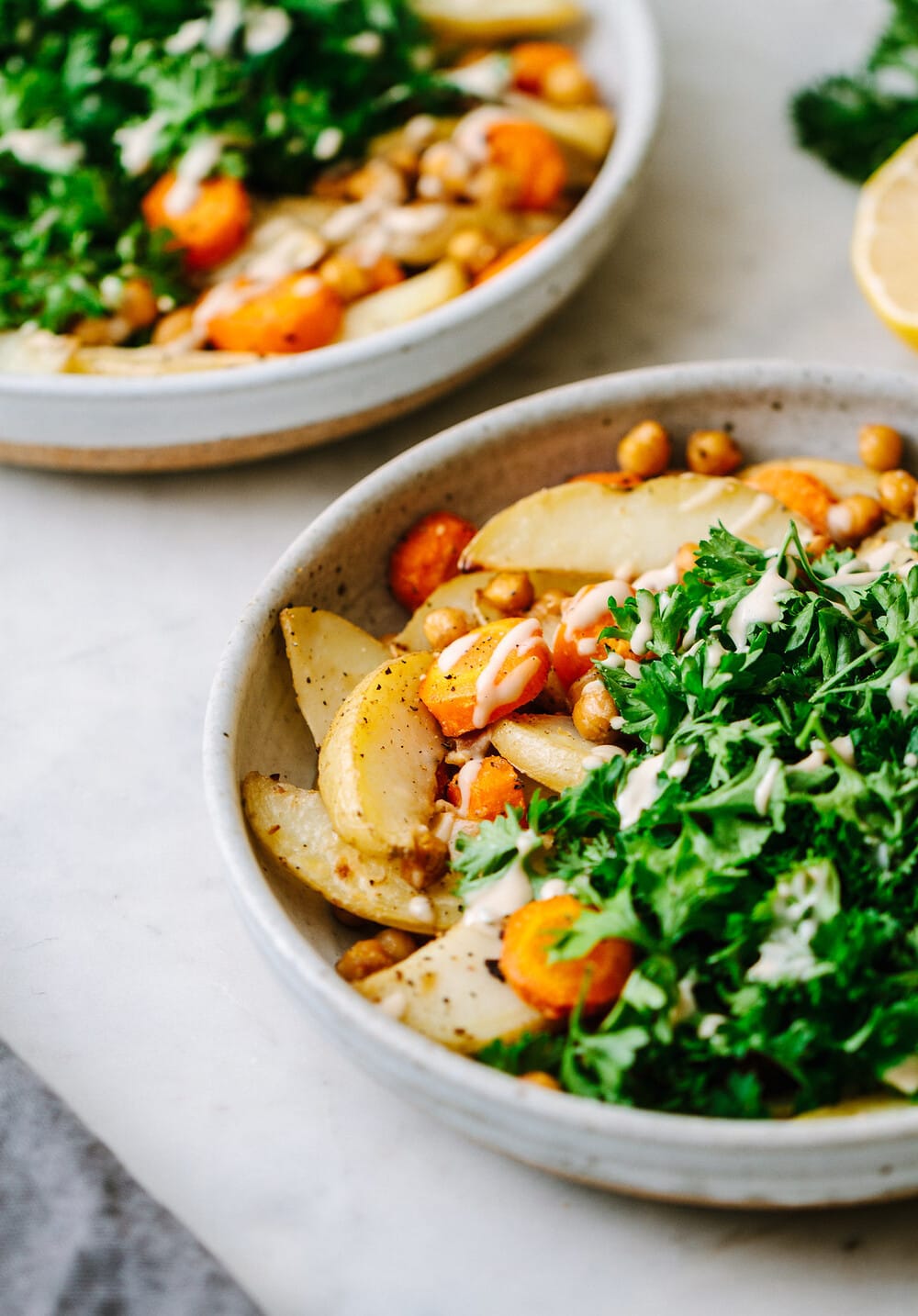 side angle view of bowl filled with a serving of chickpeas, potato and parsley.