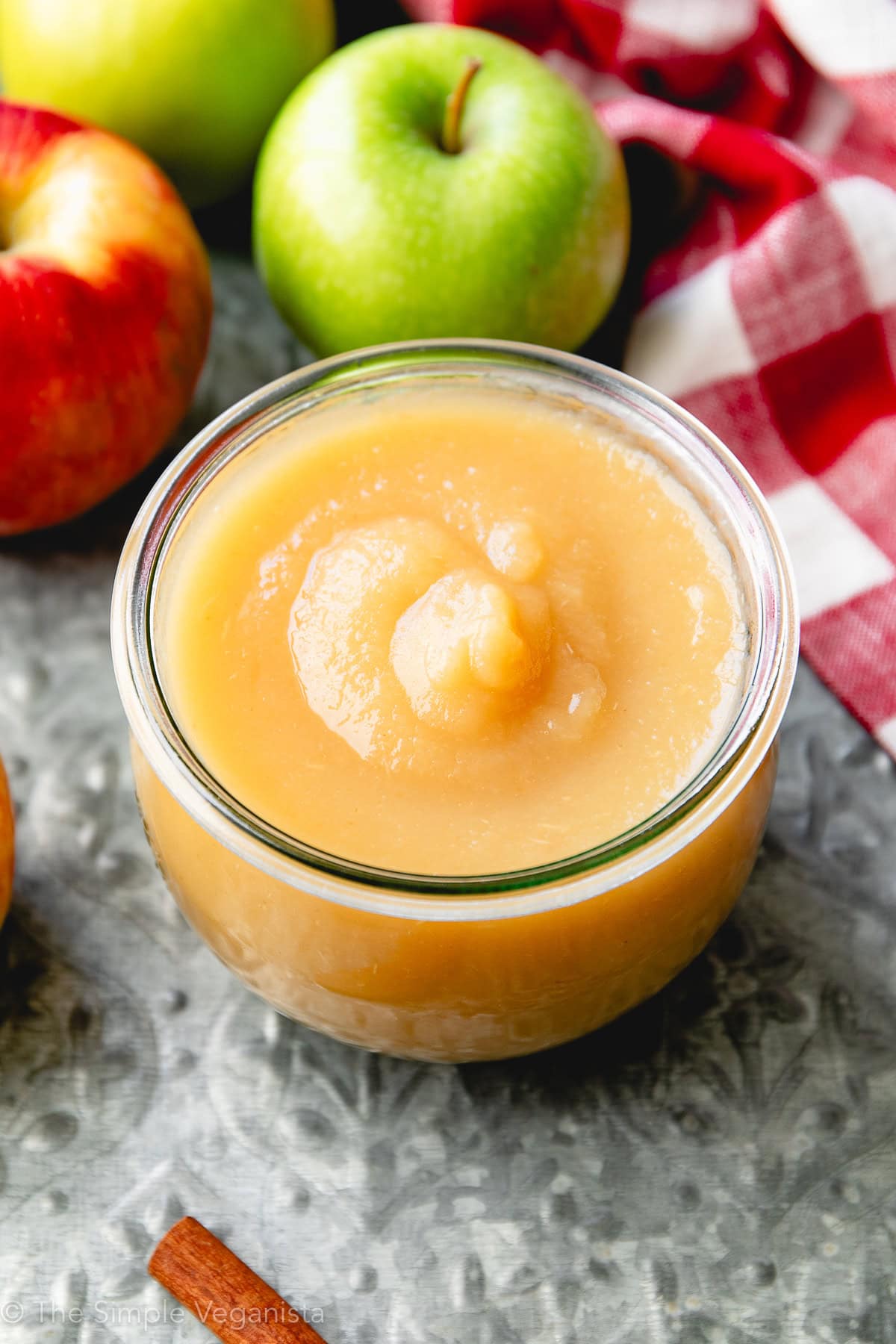 side angle view of instant pot applesauce in a glass jar with items surrounding.