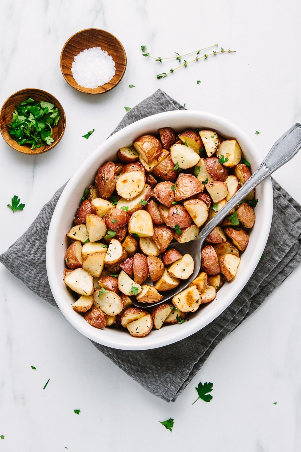 top down view of a white serving bowl with oven roasted red potatoes.