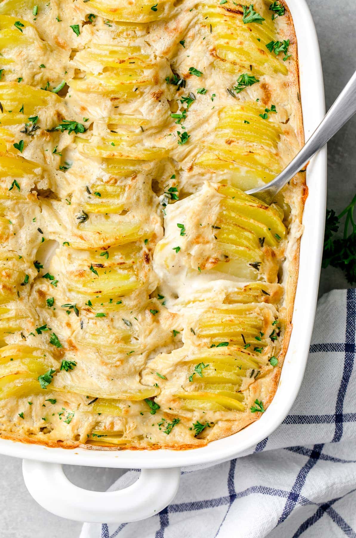 top down view of vegan scalloped potatoes with serving spoon.