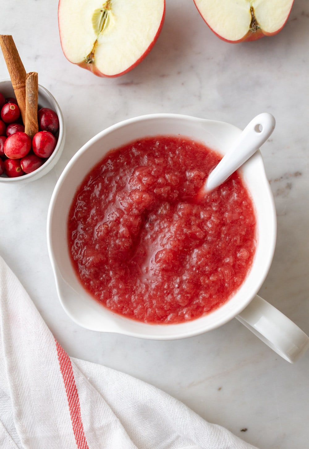 top down view of a bowl of cranberry applesauce with white spoon
