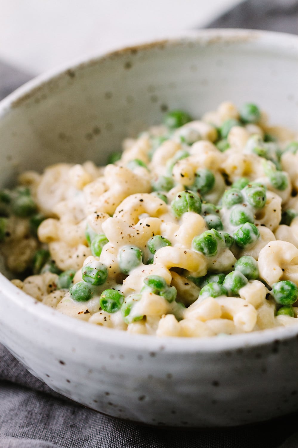 homemade vegan mac and cheese with peas in a bowl