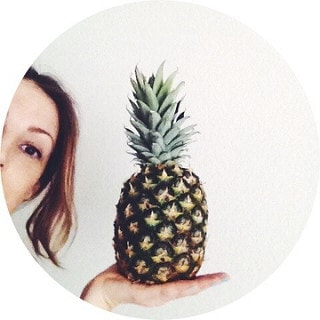 half head shot of julie, the simple veganista, holding a pineapple