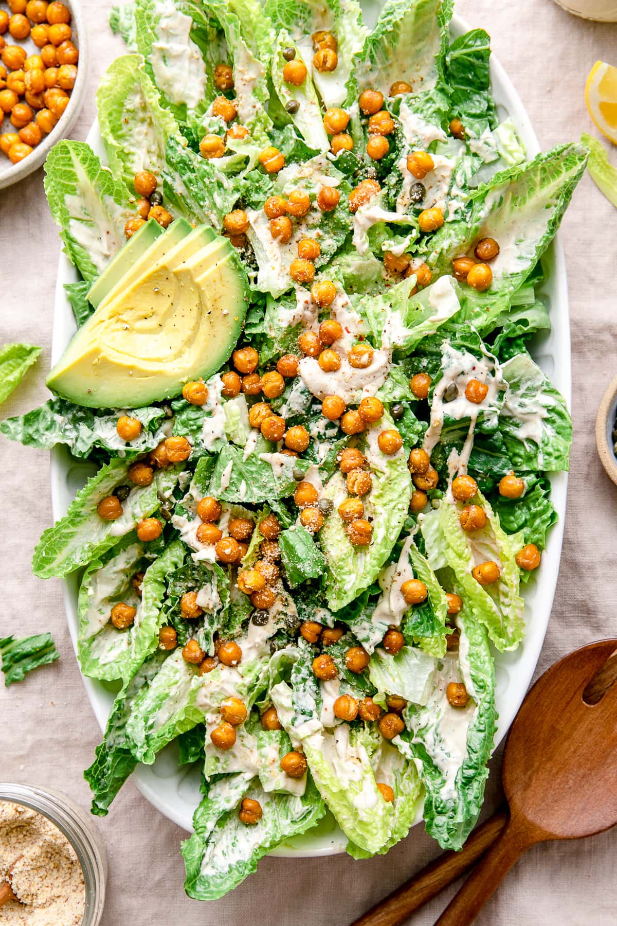 top down view of vegan caesar salad on a platter with items surrounding.