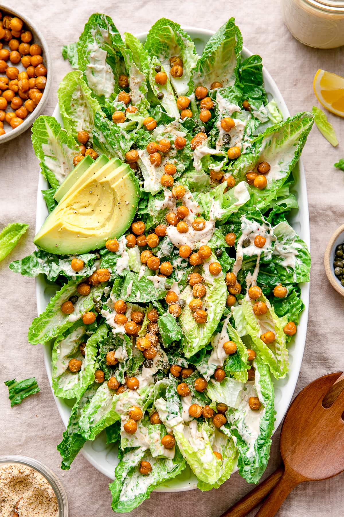 top down view of vegan caesar salad on a platter with items surrounding.