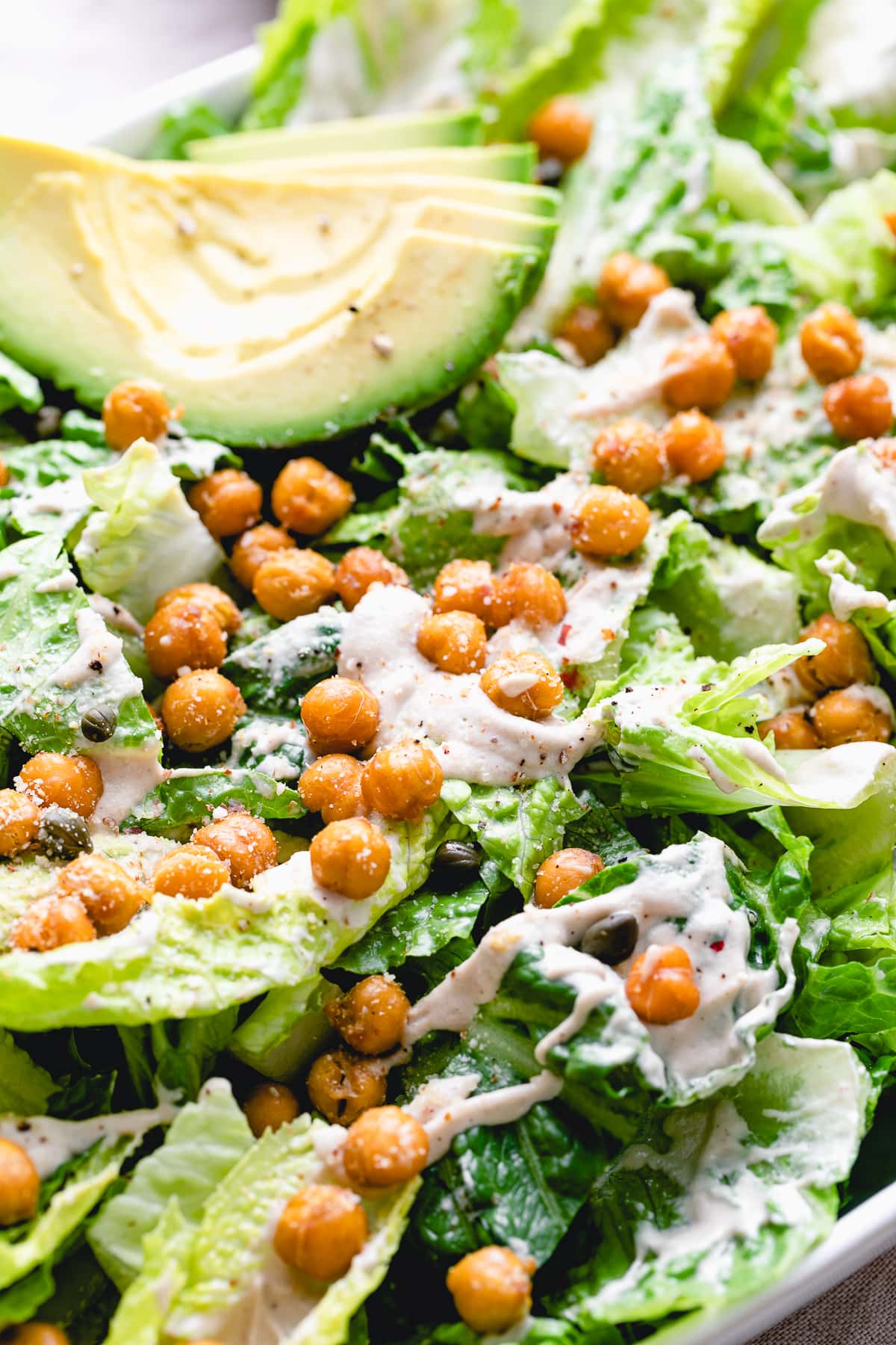 up close side angle view of the best vegan caesar salad with crispy chickpeas and avocado.