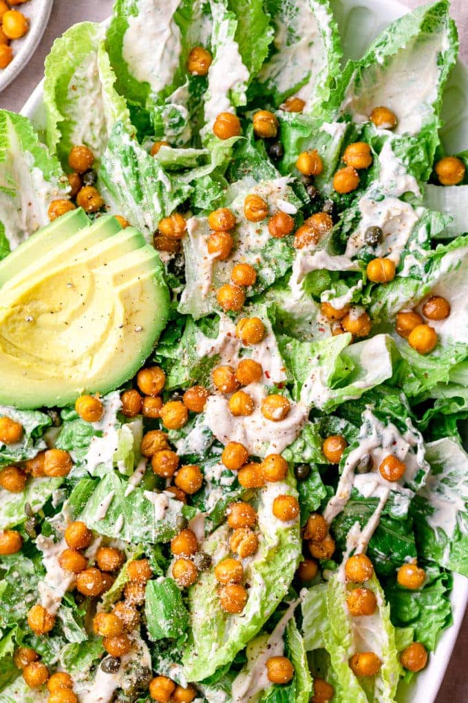 top down view of vegan caesar salad in a large white bowl.