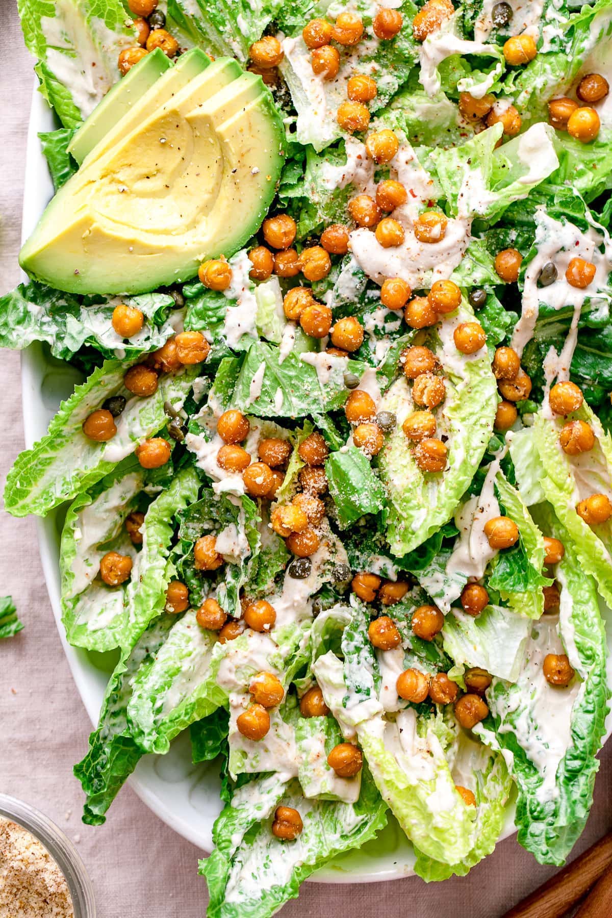 top down view of vegan caesar salad in a large white bowl. 