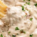 creamy caramelized vegan french onion dip in a bowl with chip