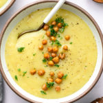 top down view of creamy vegan potato leek soup in a bowl with spoon.