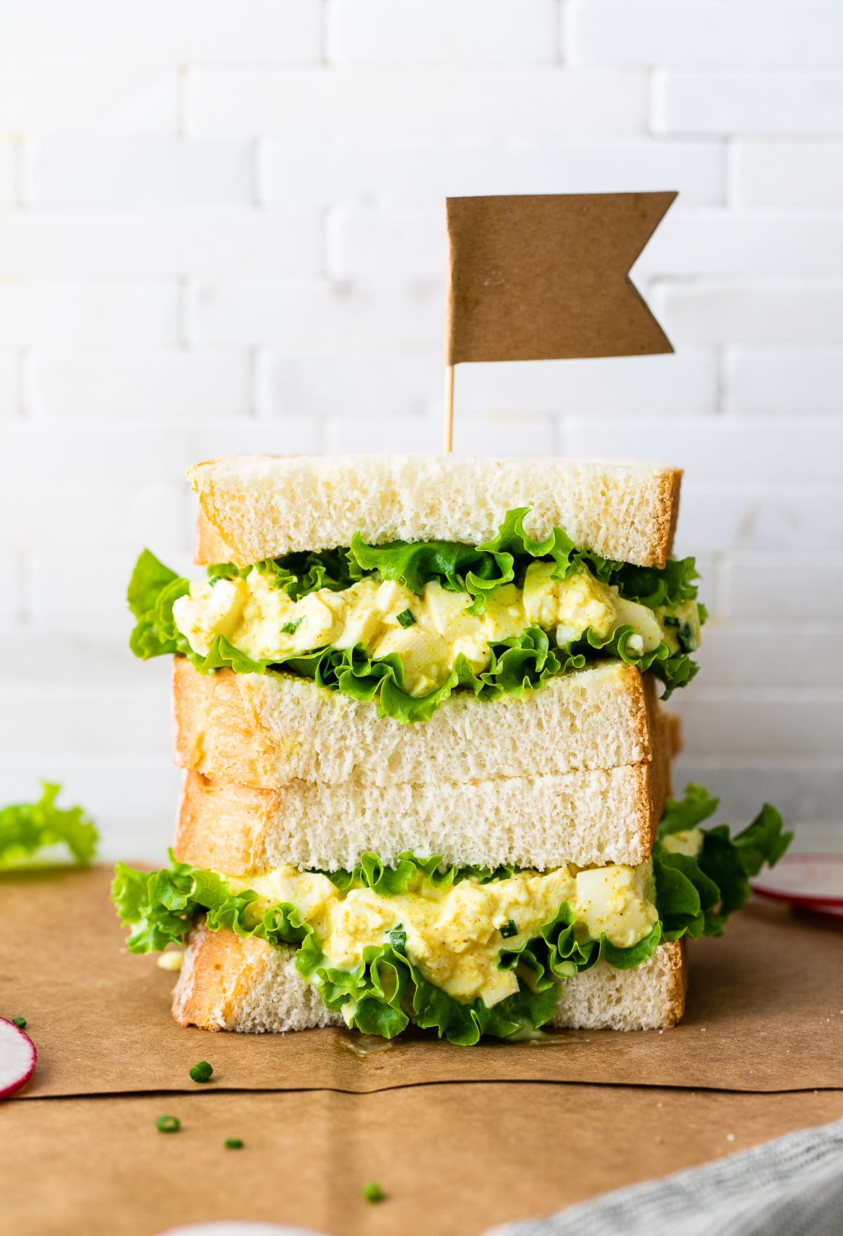 head on view of two halves of vegan egg salad sandwich stacked.