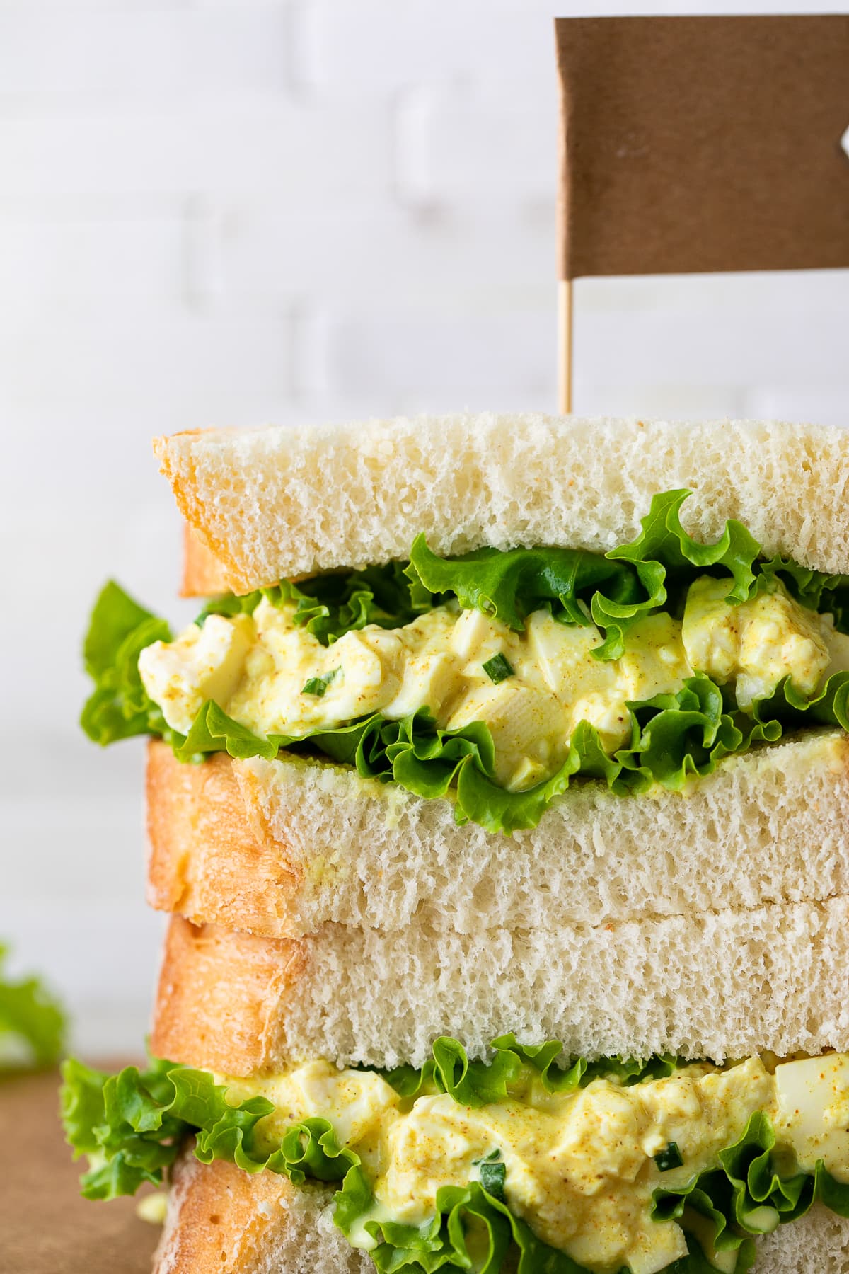 head on view of two halves of vegan egg salad sandwich stacked.