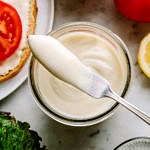 homemade vegan mayonnaise in a mason jar with butter knife ready to spread