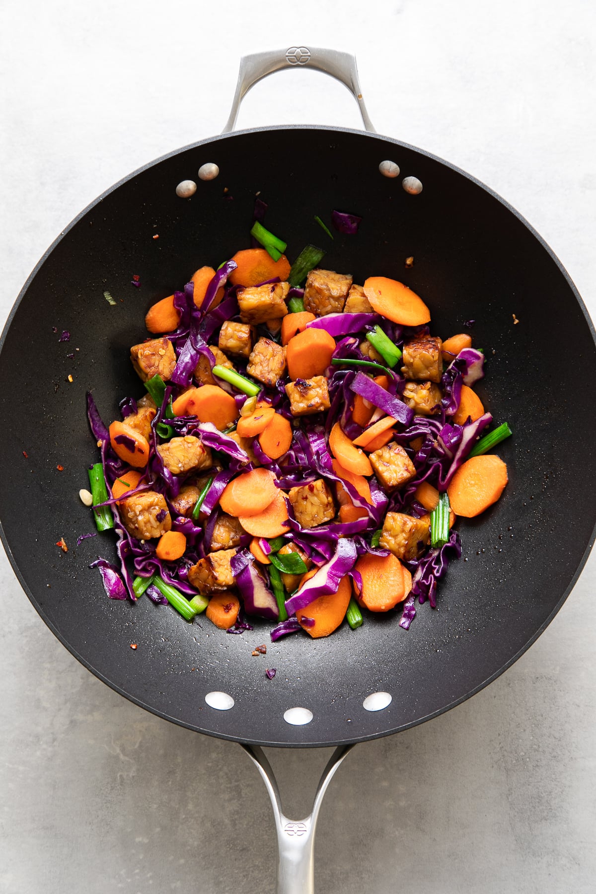 top down view of freshly cooked tempeh stir fry in a wok.